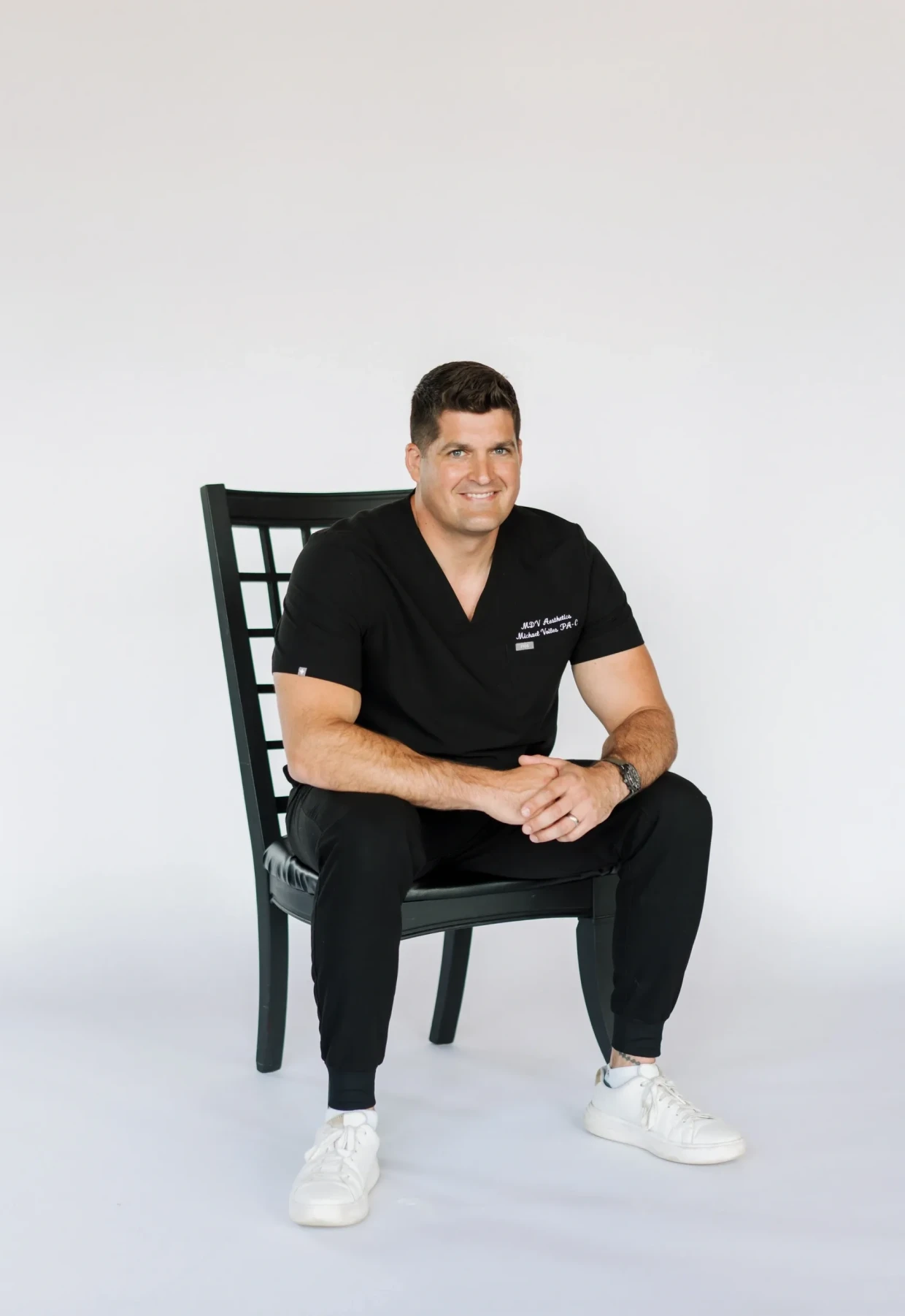 Person in black outfit with white sneakers